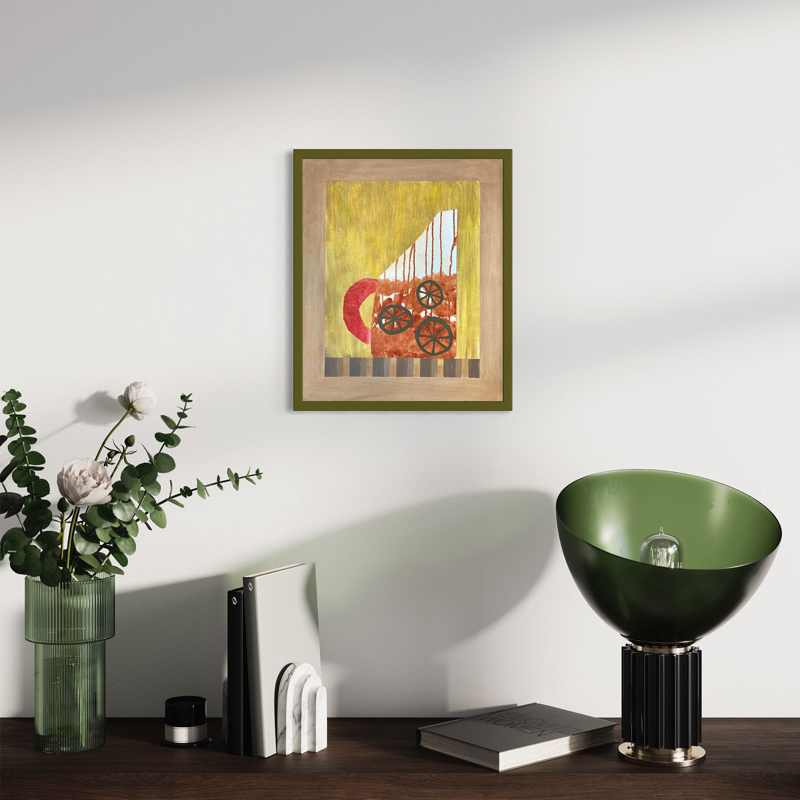 Interior modern living space and the framed abstract collage, Scraps #3 by Jenny Atina on the wall. Below, a wooden surface holds a green vase with white flowers, a book, and a stylish lamp.